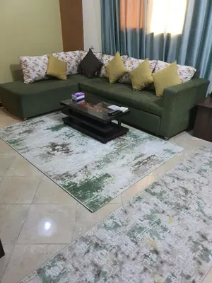 a living room with a green couch and a rug at Abeer suites 2 in Hurghada