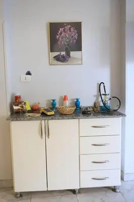 a white kitchen counter with a vase of flowers on it at Nefertarie Guest House in Luxor