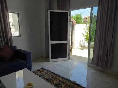 a living room with a door open to a patio at Nefertarie Guest House in Luxor