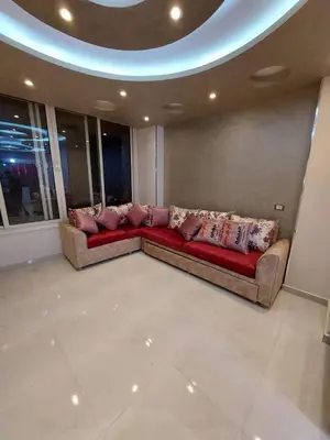 a living room with a red couch in a room with windows at شقة فندقية على البحر in Hurghada