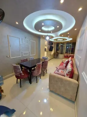 a living room with a couch and a table with chairs at شقة فندقية على البحر in Hurghada