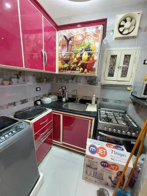 a kitchen with red cabinets and a sink at شقة فندقية على البحر in Hurghada