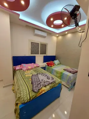 two beds in a room with a ceiling fan at شقة فندقية على البحر in Hurghada