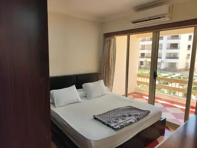 a bed in a room with a large window at 2bedroom apartment in Summer Land Beach Resort in Hurghada