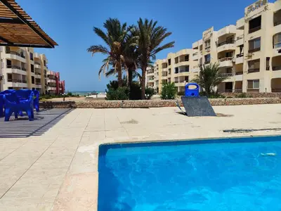 a swimming pool with a blue toy next to some buildings at 2bedroom apartment in Summer Land Beach Resort in Hurghada