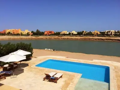 a swimming pool next to a body of water at Gorgeous Villa in Gouna with Heated Private Pool in Hurghada