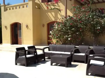 a group of black chairs and a building at Gorgeous Villa in Gouna with Heated Private Pool in Hurghada