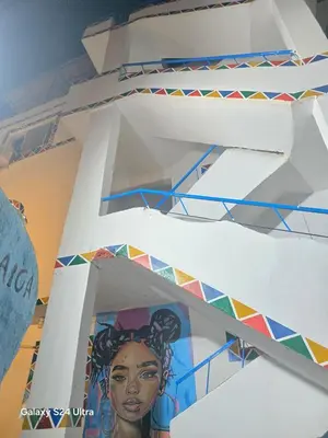a white staircase with a painting on the side of it at Mostafa Jamaica guesthouse in Aswan