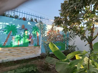 a mural on the side of a building with plants at Noby Guest House in Luxor