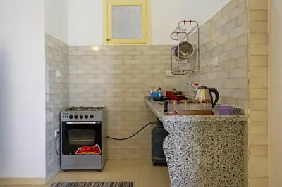 a kitchen with a stove and a counter top at Noby Guest House in Luxor
