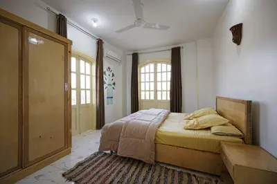 a bedroom with a bed and a large window at Noby Guest House in Luxor