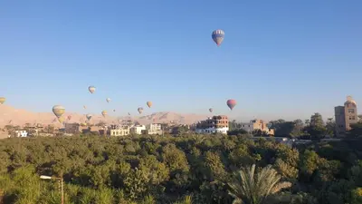 a group of hot air balloons flying over a city at Egypt Villa Garden in Luxor