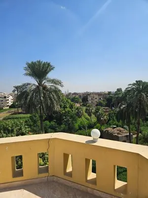 a balcony with a view of a city with palm trees at Egypt Villa Garden in Luxor