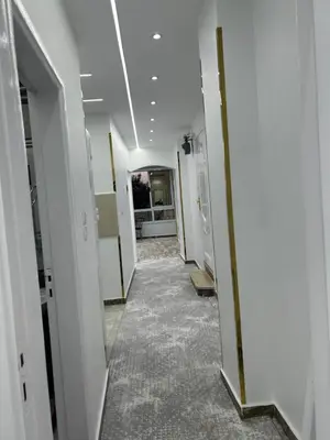 a hallway with white walls and a row of doors at Queen of the Nile hotel apartments in Luxor