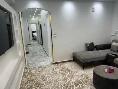 a living room with a couch and a mirror at Queen of the Nile hotel apartments in Luxor