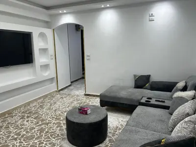 a living room with a couch and a flat screen tv at Queen of the Nile hotel apartments in Luxor