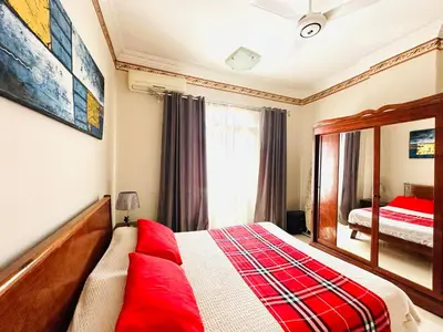 a bedroom with a red bed and a mirror at RITA HOUSE SEA VIEW. Hurghada center in Hurghada