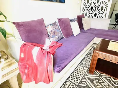 a purple couch in a living room with a table at RITA HOUSE SEA VIEW. Hurghada center in Hurghada