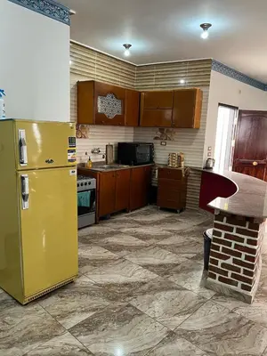 a kitchen with a yellow refrigerator and a stove at Valley Of The Kings House in Luxor
