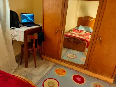 a small bedroom with a mirror and a bed with a laptop at Nefertari Guest House in Aswan