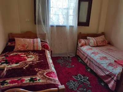 a bedroom with two beds and a window at Nefertari Guest House in Aswan
