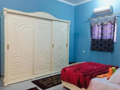 a bedroom with a white bed and blue walls at Bob Marley Guest House in Luxor