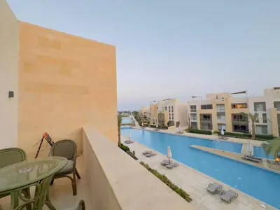 a balcony with a view of a pool and buildings at Mangrovy 2 BR Gouna in Hurghada