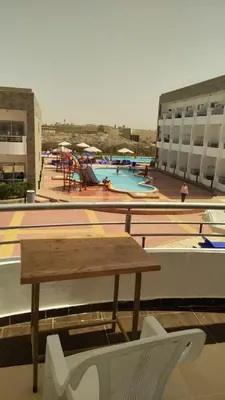 a table and chairs on top of a building with a pool at Cecelia Resort in Hurghada