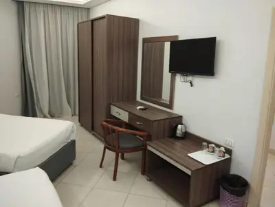a hotel room with a bed and a desk with a mirror at Cecelia Resort in Hurghada