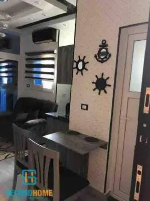 a living room with a table and a clock on the wall at Oasis resort-Nice Condo -B31-Al Ahyaa - Hurghada in Hurghada