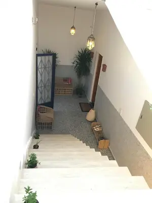 a hallway with stairs and chairs and potted plants at Luxury Ground Floor Appartment , BEST mountain views! near Temples in Luxor