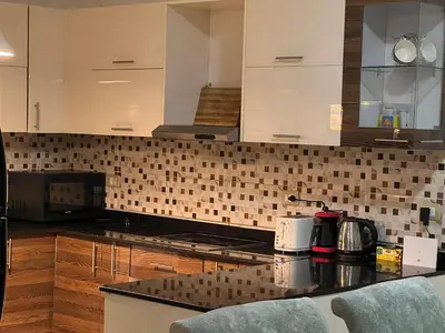 a kitchen with white cabinets and a black counter top at Villa KUBA luxury private pool Hurghada in Hurghada