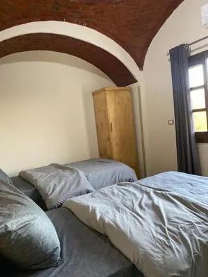 two beds in a room with a window and a room with at Tasneem Palace in Luxor