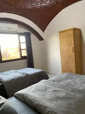 a bedroom with two beds and a window at Tasneem Palace in Luxor