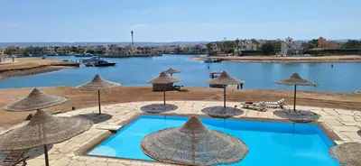 a resort with a pool and umbrellas and a river at El Gouna Fanadir Lagoon 2-Bedroom Pool and Lagoon View Sleeps 4 Persons, Close to Abu Tig Marina, Mangroovy, and Kite Centers in El Gouna