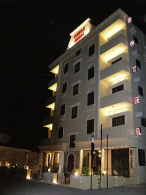 a hotel building with a sign on it at night at Luxor Hotel Hurghada in Hurghada