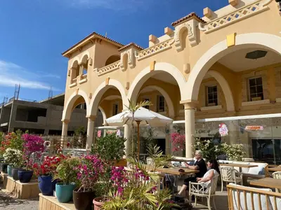 two people sitting at tables in front of a building at Hurghada Sahl Hasheesh sea-view Villa with private pool in Hurghada