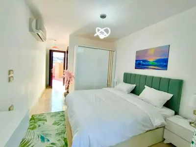 a bedroom with a large bed with a green headboard at Hurghada Sahl Hasheesh sea-view Villa with private pool in Hurghada