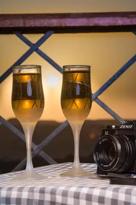 two glasses of wine sitting on a table with a camera at ASWAN NILE PALACE (swimming pool-rooftop-Nile view) in Aswan
