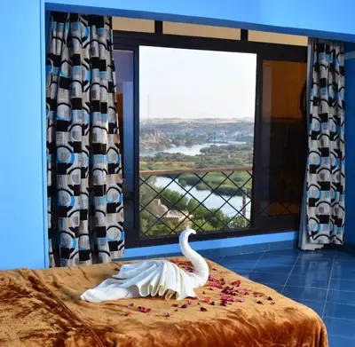 a swan toy on a bed in a room with a window at ASWAN NILE PALACE (swimming pool-rooftop-Nile view) in Aswan
