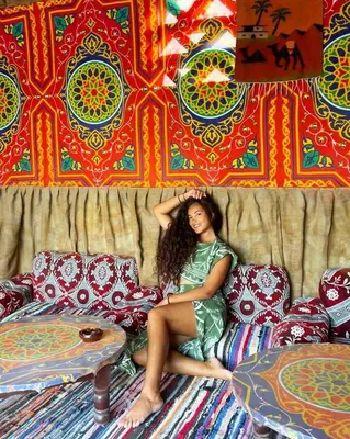 a woman sitting on a couch in a room at Lawanda Nubian B&B in Aswan