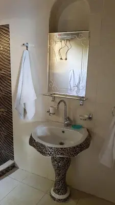 a bathroom with a sink and a mirror at Golden palace Nile view - Appartment in Luxor