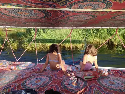two girls sitting on a boat in the water at My Dream Nile Felucca in Aswan