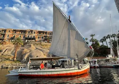 a small boat with a sail in the water at My Dream Nile Felucca in Aswan