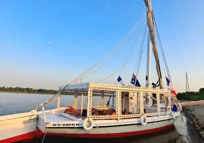 a boat is docked on the water at My Dream Nile Felucca in Aswan