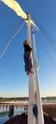 a person standing on top of a ladder at My Dream Nile Felucca in Aswan