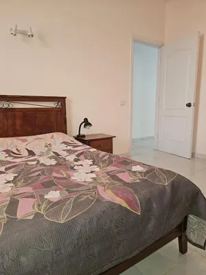 a bedroom with a bed with a flower pattern on it at Hurghada Village sea view in Hurghada