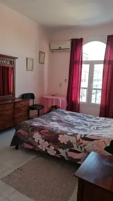 a bedroom with a bed and a table and a window at Hurghada Village sea view in Hurghada