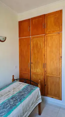 a bedroom with wooden cabinets and a bed at Hurghada Village sea view in Hurghada