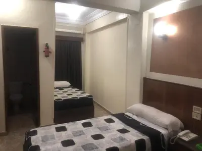 a small room with two beds and a mirror at New Saint Catherine Hotel in Luxor